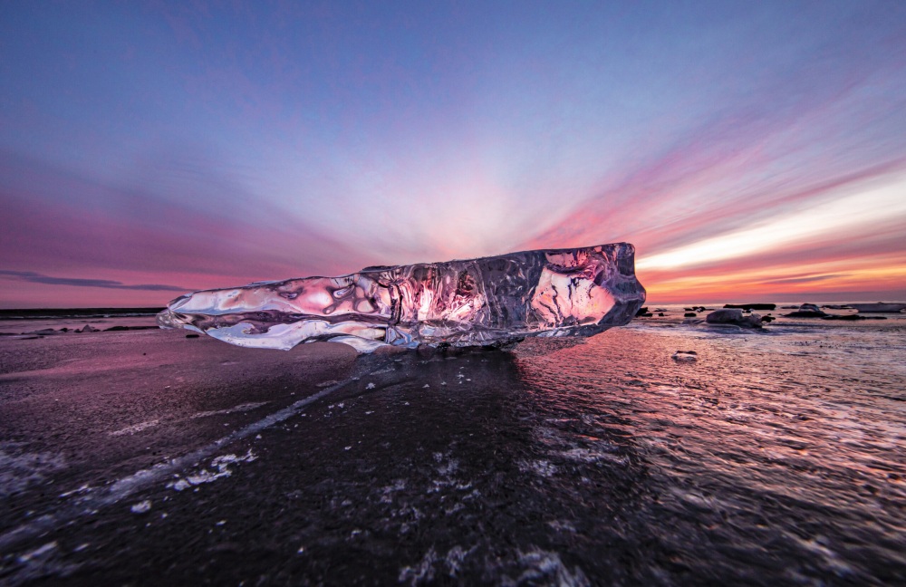 On another January day, before sunrise, the clouds are dyed red by the sunlight, and the color is reflected in the ice. Even at the same time of morning, the appearance and color of jewelry ice will differ from day to day. ⒸKishimoto Hideo